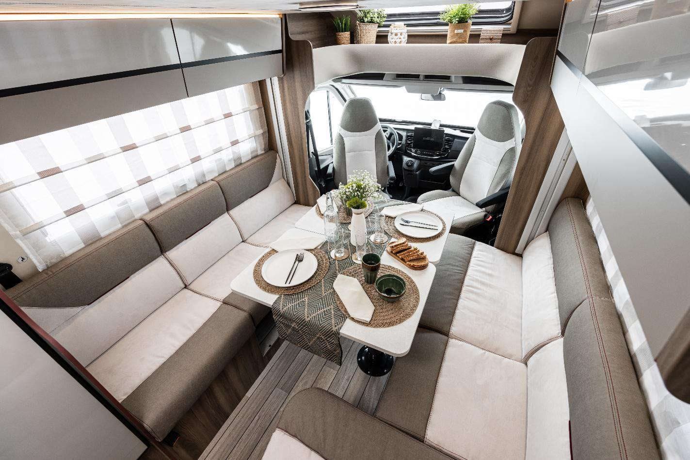 Interiorul unei autorulote Roller Team Kronos — dinetă în L și cabina de conducere